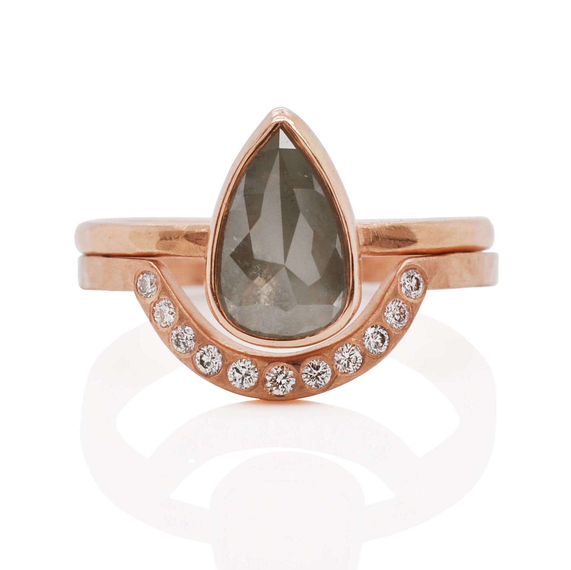 Modern engagement ring wedding set. the solitaire ring is teardrop shaped, rosecut, salt and pepper diamond, bezel set in rose gold on a hammered band. Stacked with a contour band with inset white diamonds