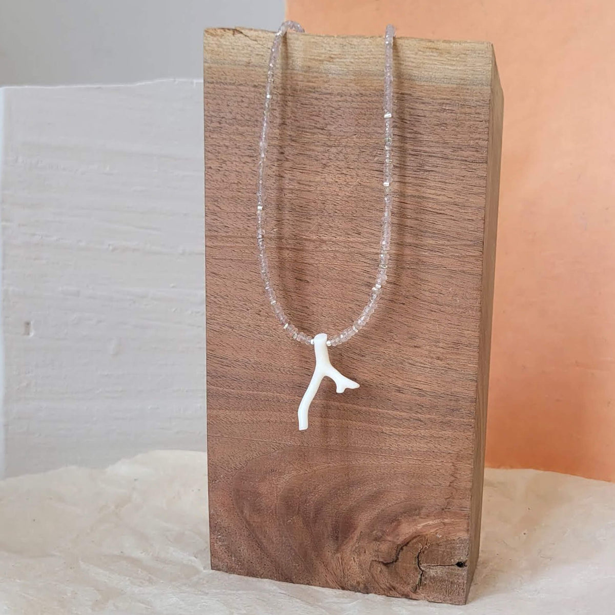 White Coral Branch on a Faceted Peach Sapphire Bead Strand