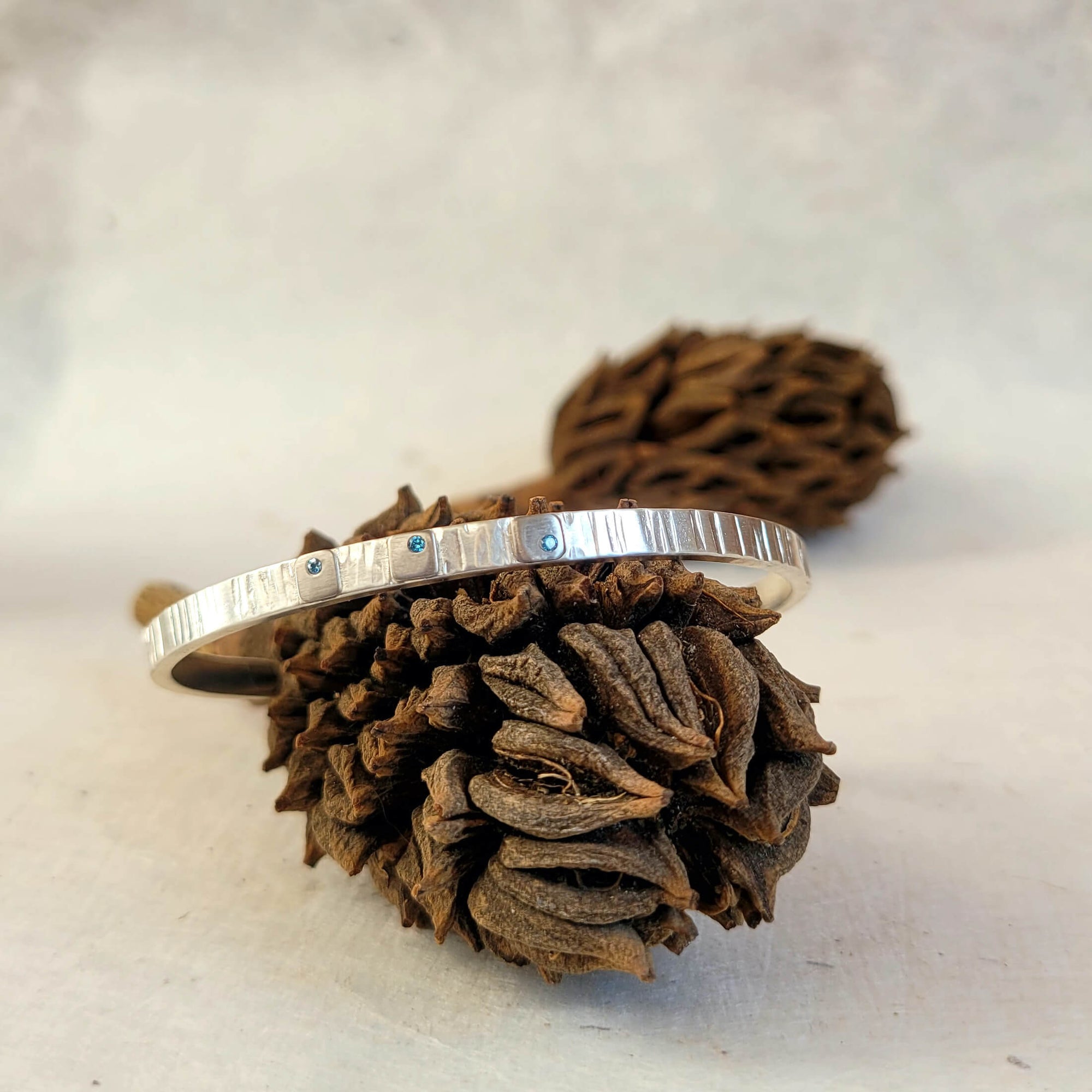Handmade cuff bracelet with blue diamond accents. Made with recycled sterling silver and palladium.
