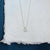 Handmade sterling silver cell pendant with flush set blue diamonds. EC Design Jewelry in Minnapolis, MN.