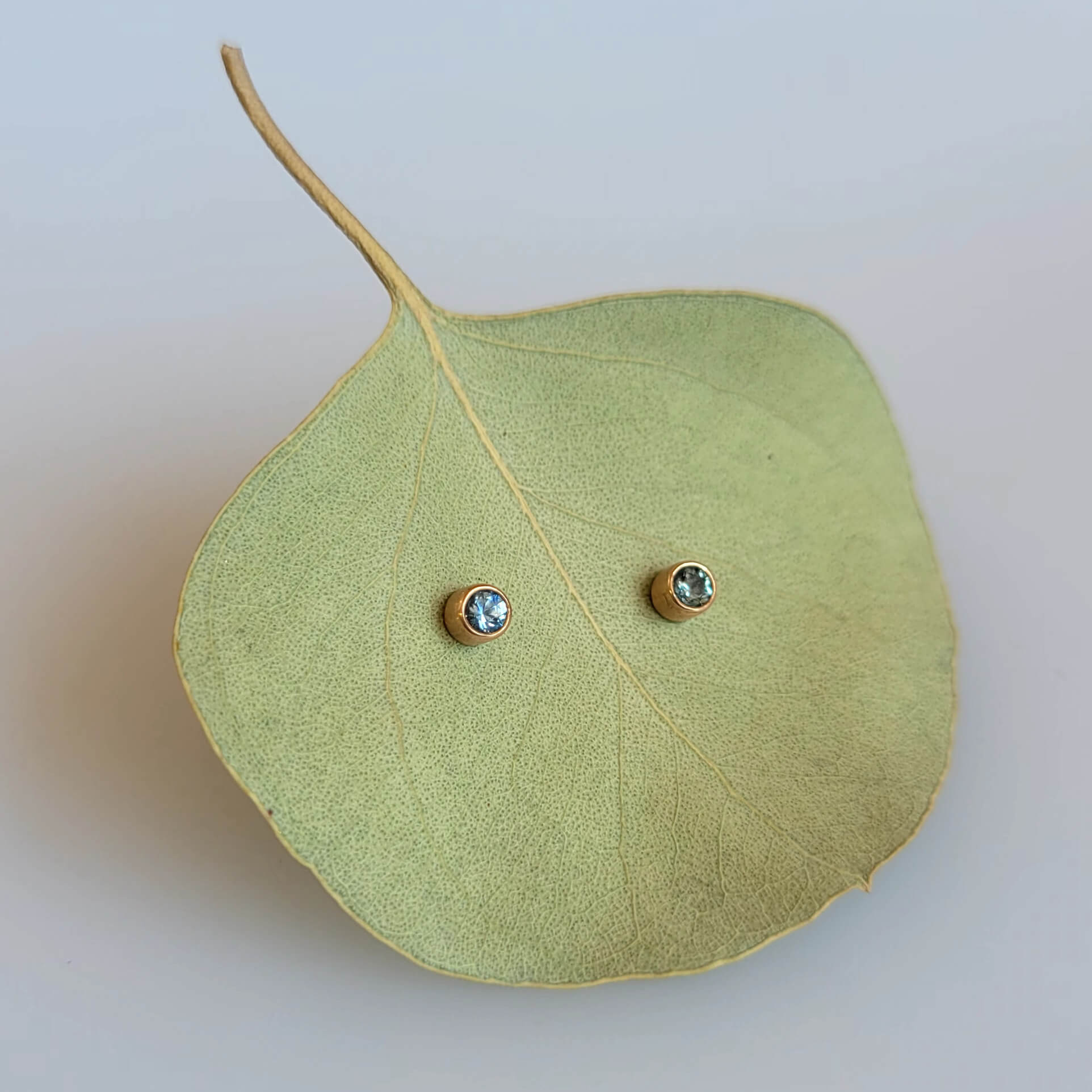 Blue Montana sapphire stud earrings in rose gold settings. Made with recycled metal and conflict-free stones.