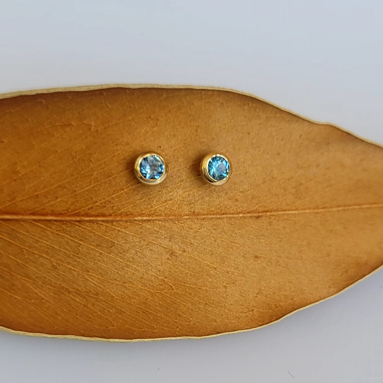 Montana sapphire stud earrings in recycled yellow gold martini settings. Handmade by EC Design Jewelry in Minneapolis, MN.