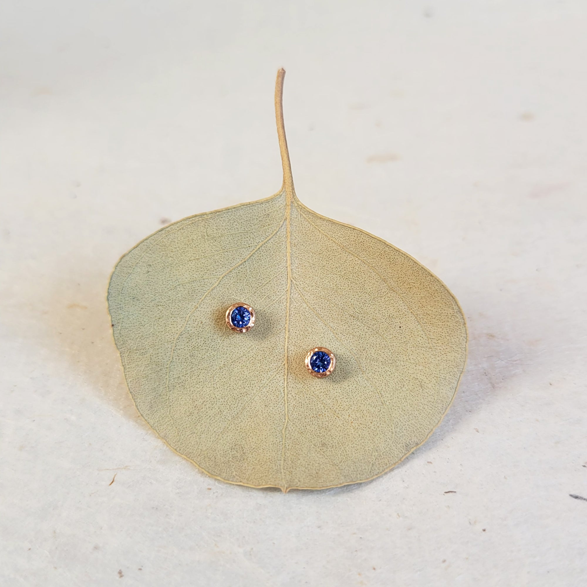 Round Brilliant Blue Sapphire Stud Earrings in Hammered Rose Gold