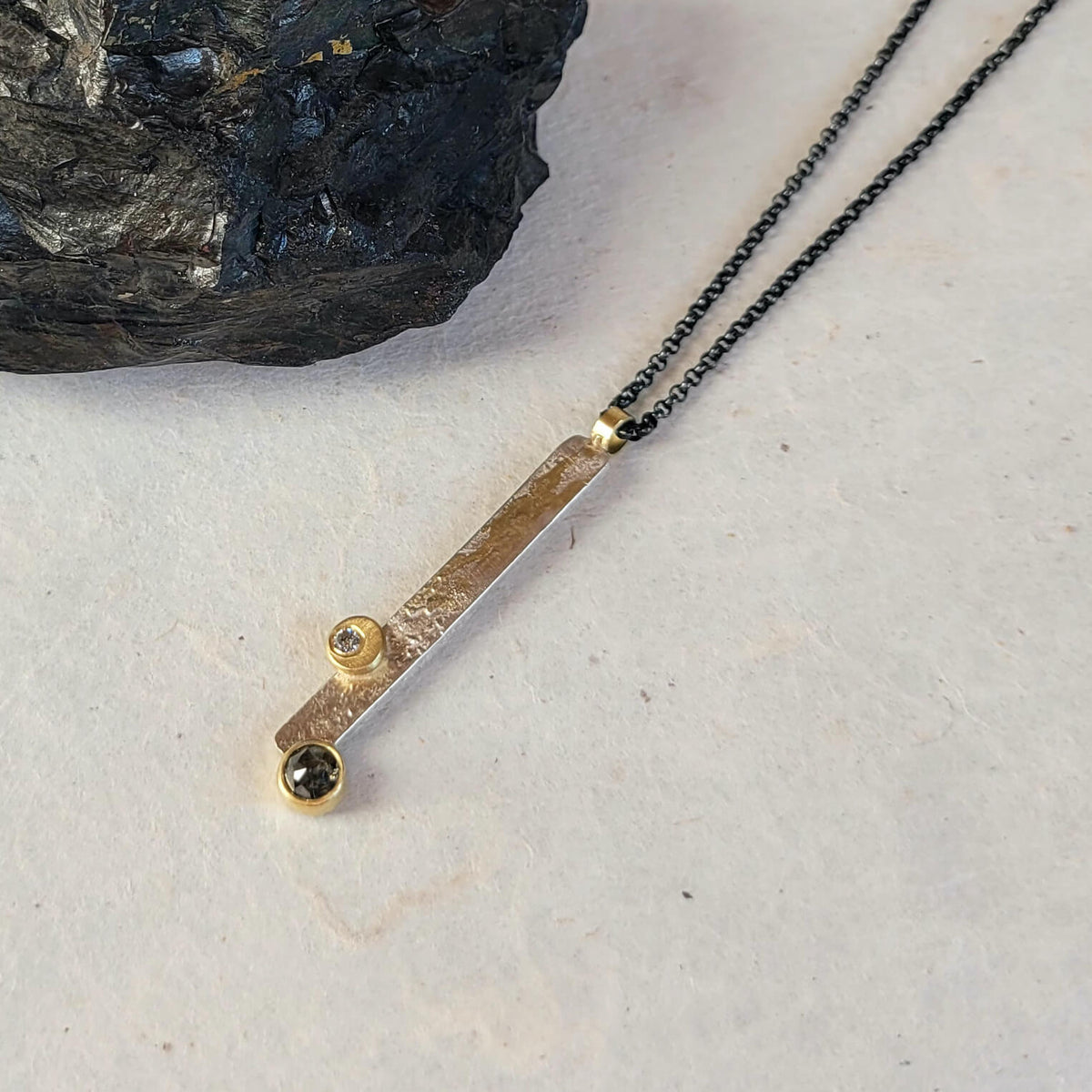 Double diamond necklace with salt and pepper diamonds on hammered silver with an oxidized chain. Handmade by EC Design Jewelry in Minneapolis, MN.