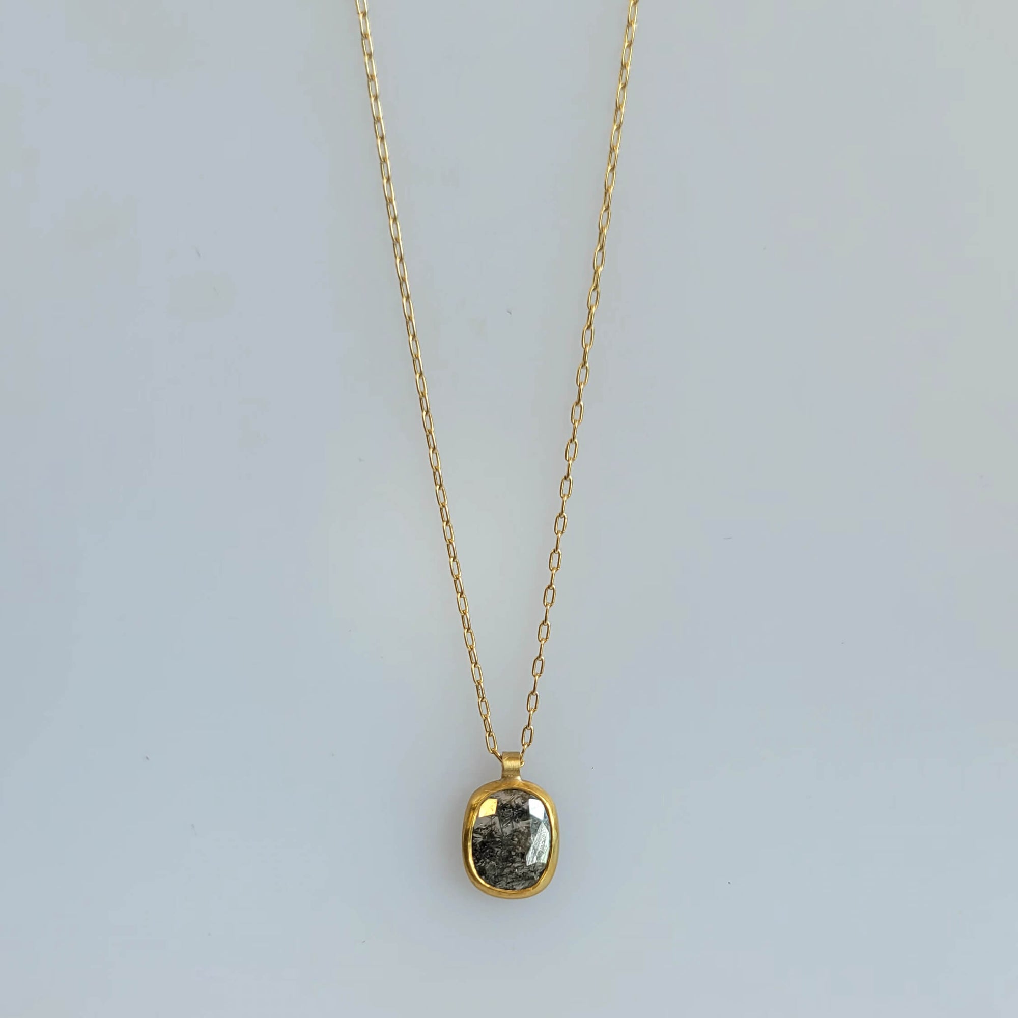 Diamond pendant in a solid gold setting on a gold chain.