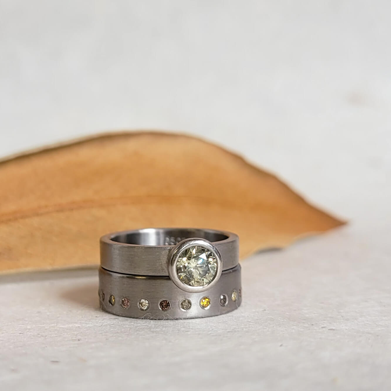 Satin finished palladium wedding band with flush set autumn diamonds. Handmade by EC Design Jewelry in Minneapolis, MN.