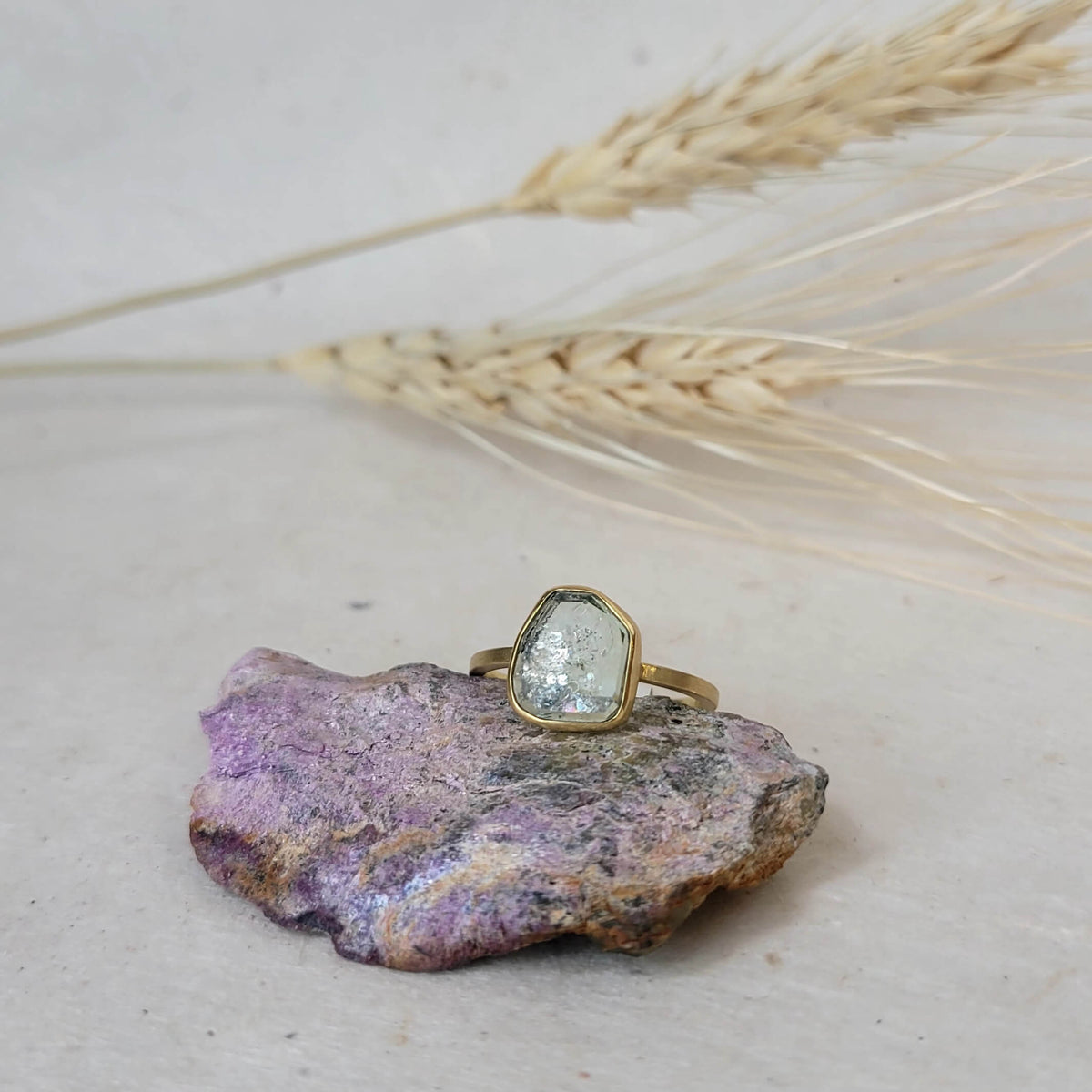 Sapphire slice set in yellow gold with a split shank and open back setting.