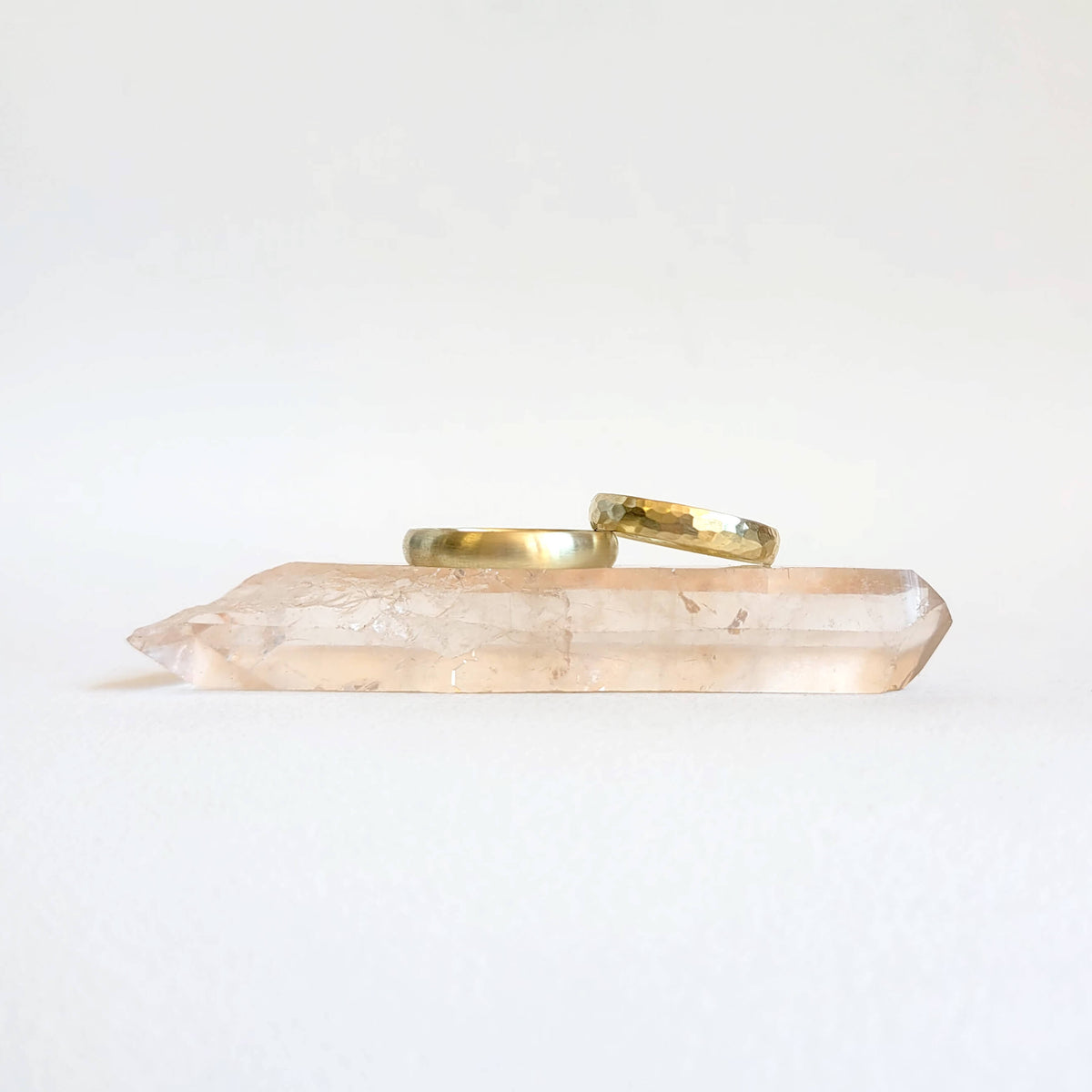 Crystal point with gold ring on a white background