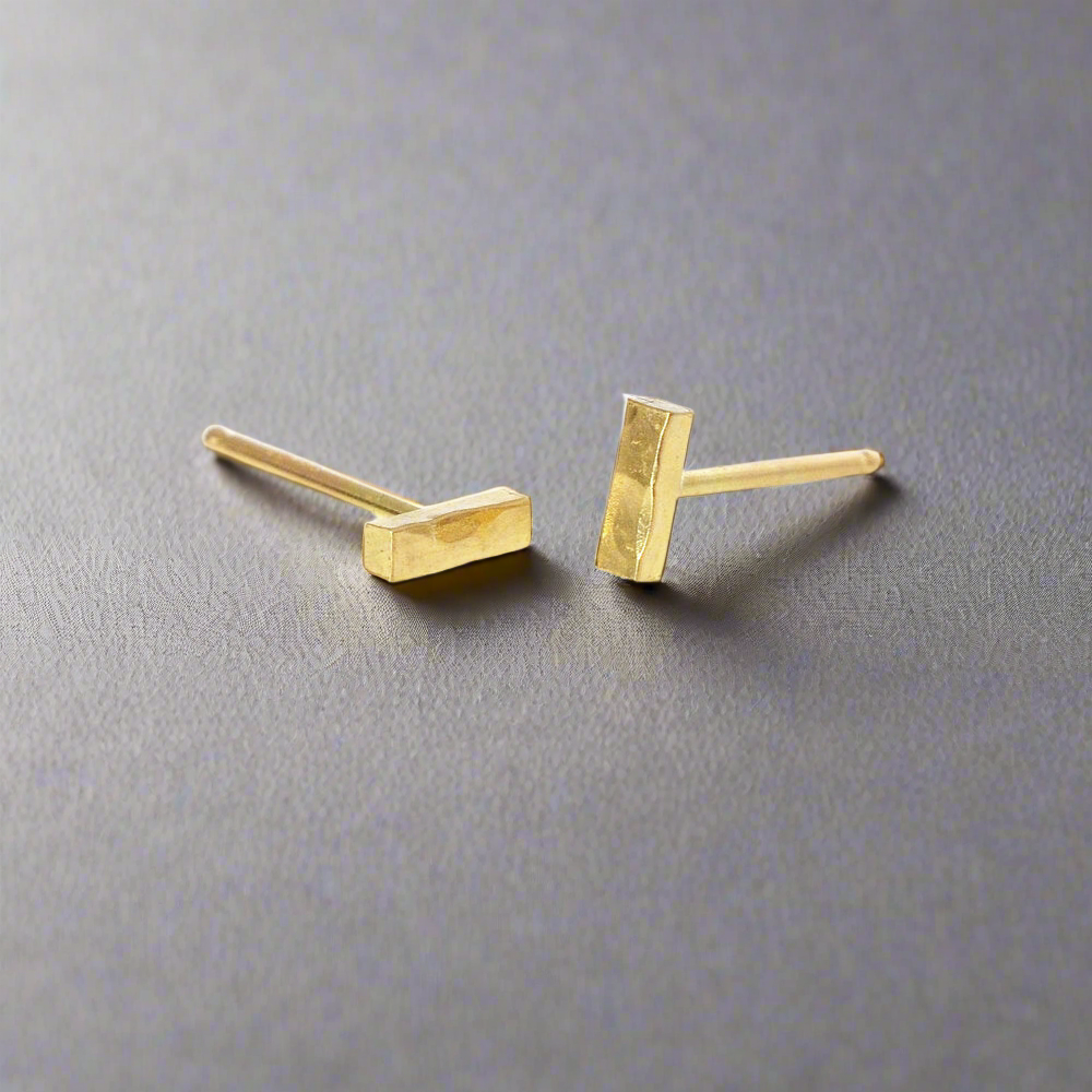 Linear and round hammered solid gold bar studs.