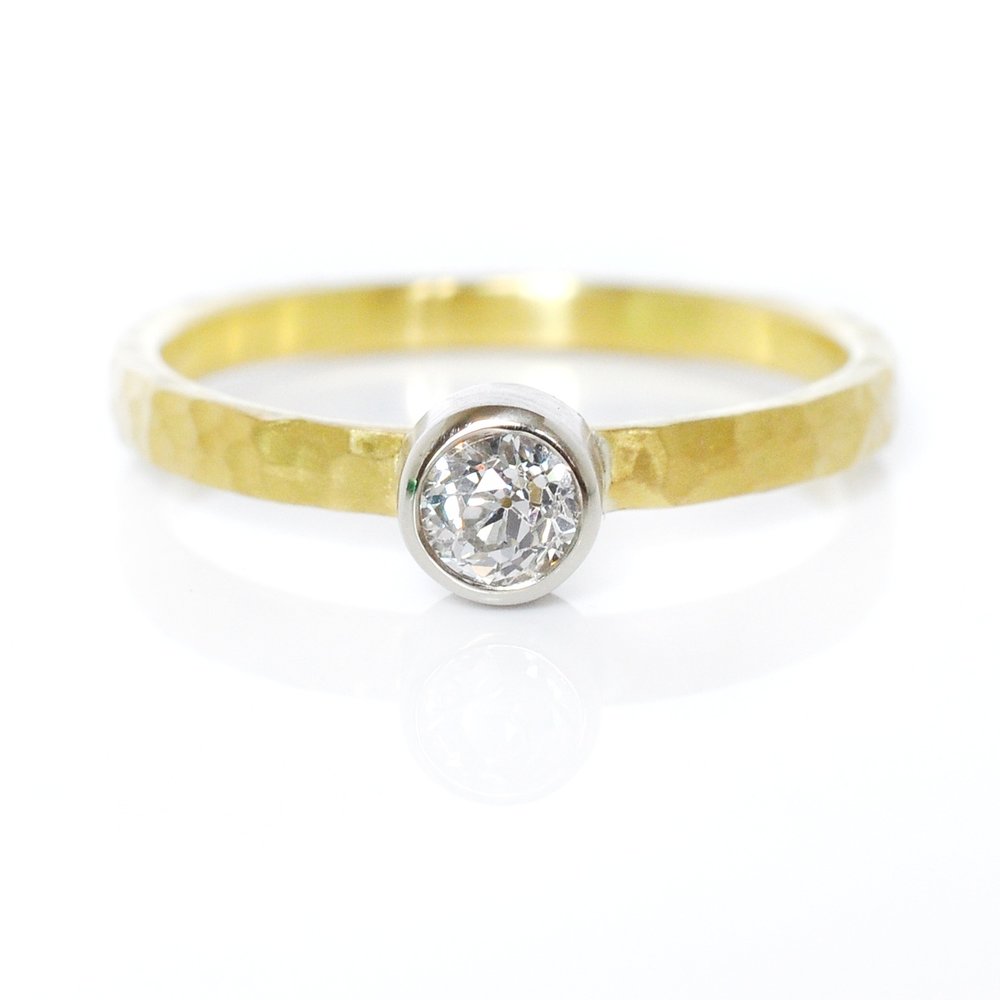 Hand hammered yellow gold band with bezel set round brilliant diamond. Handmade by EC Design Jewelry in Minneapolis, MN.