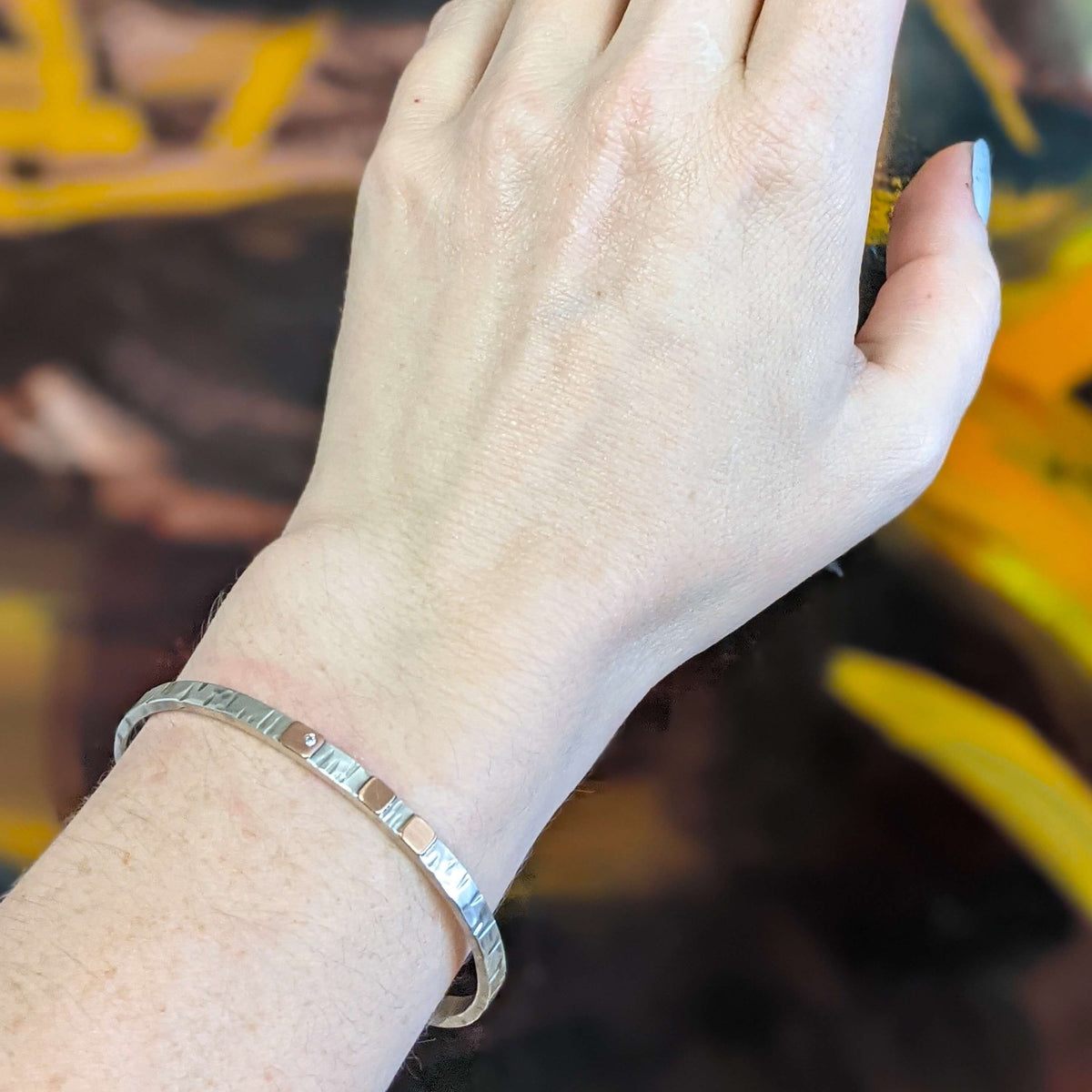 Hammered sterling silver cuff with rose gold cells and flush set diamond accent.