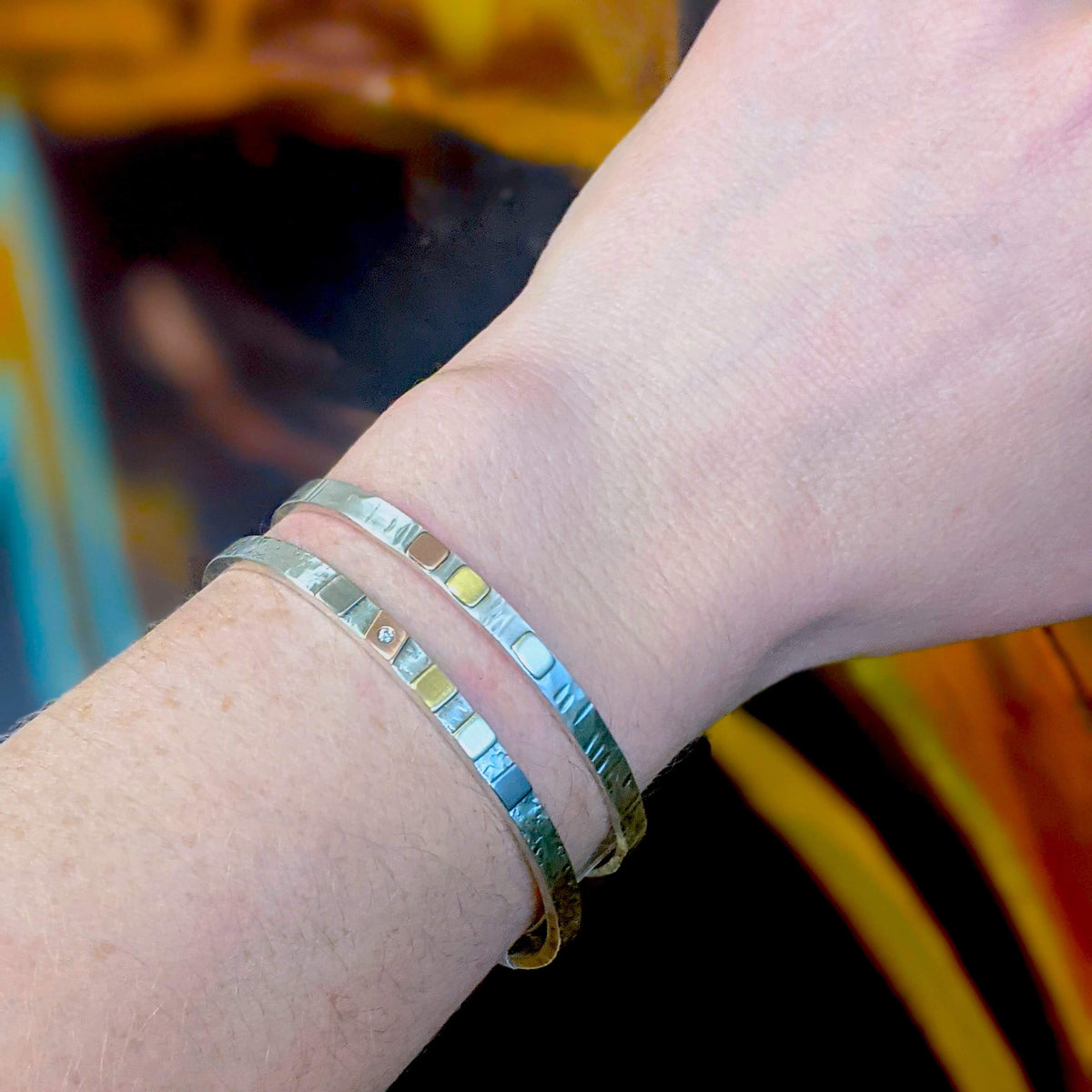 Hammered sterling silver cuffs with mixed metal cells and diamond accent.