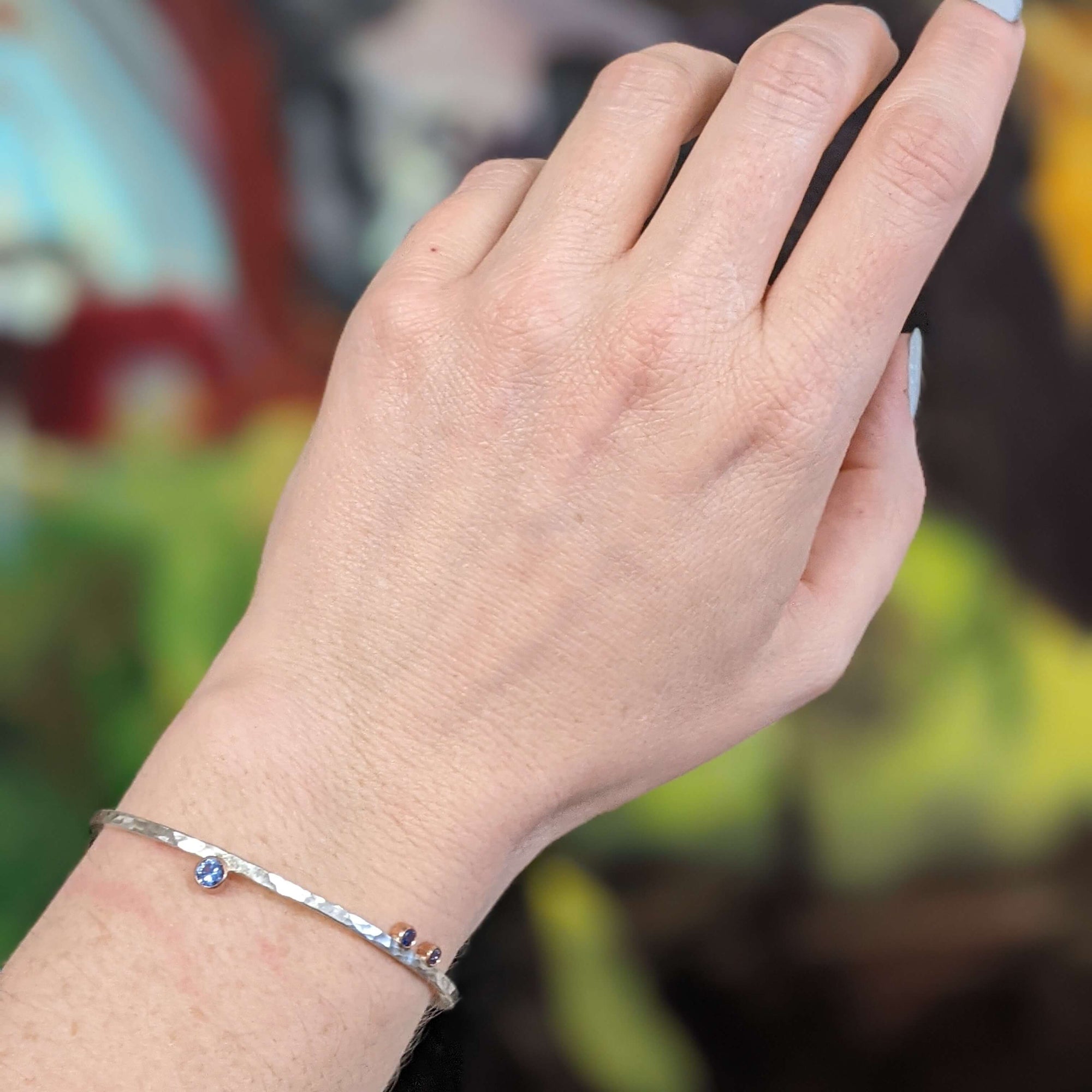 Sterling silver cuff with rose gold bezel set blue sapphires.