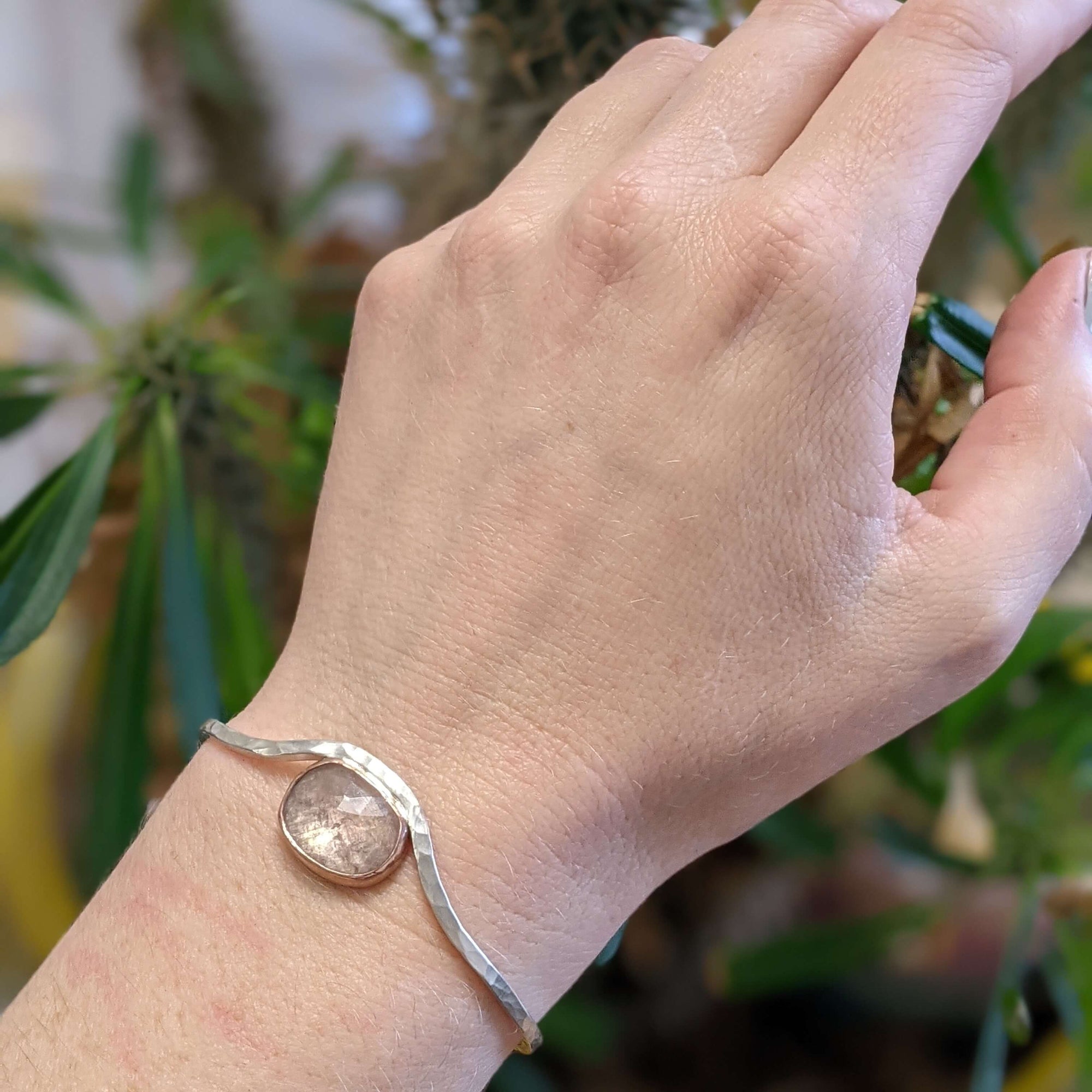 Hammered cuff bracelet with pale peach sapphire bezel set in rose gold.