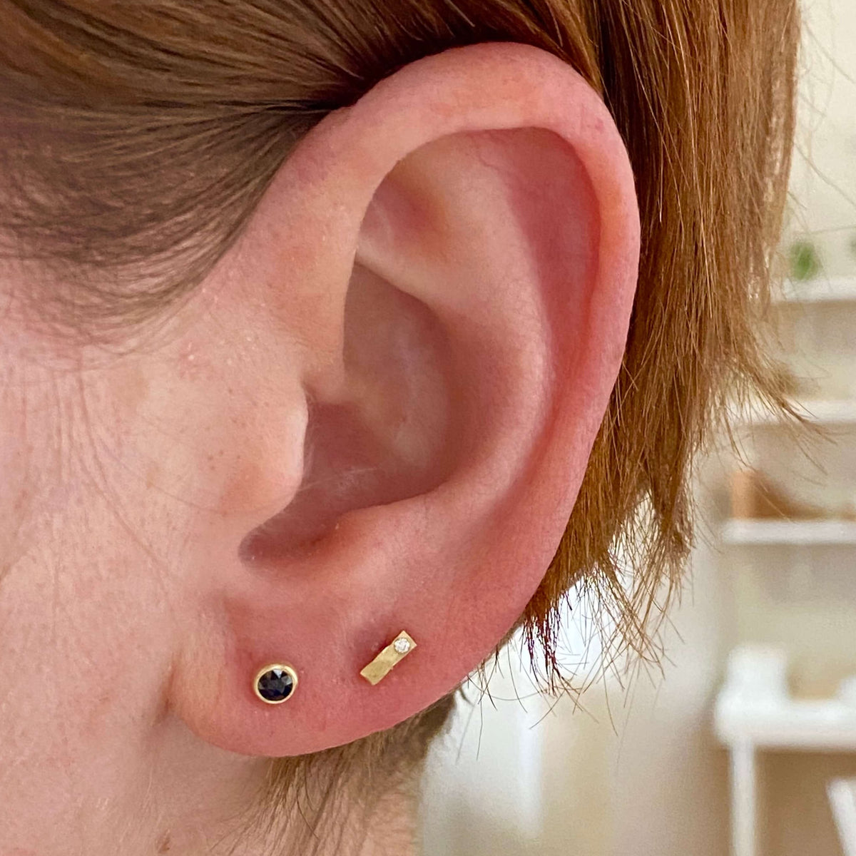 Black diamond and yellow gold studs, shown with hammered yellow gold and white diamond bar studs. Handmade by EC Design Studio in Minneapolis, MN.