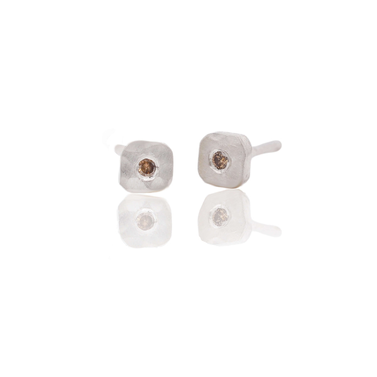 Hammered sterling silver studs with center-set champagne diamonds. Handmade by EC Design Jewelry in Minneapolis, MN.