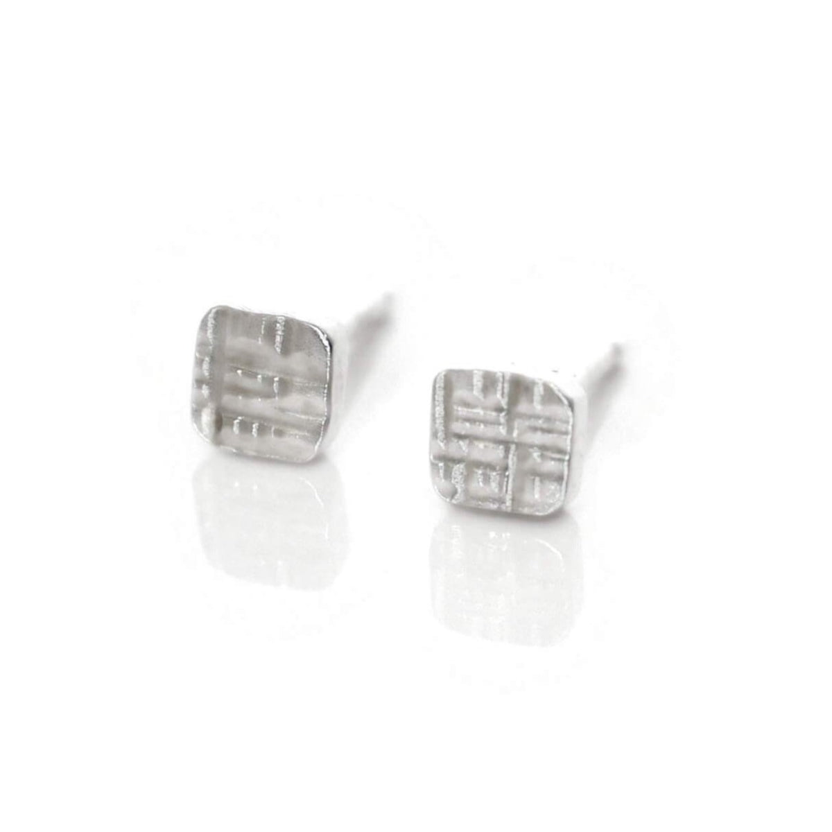 Sterling silver square studs in linear hammered finish. Handmade by EC Design Studio in Minneapolis, MN using recycled metal.