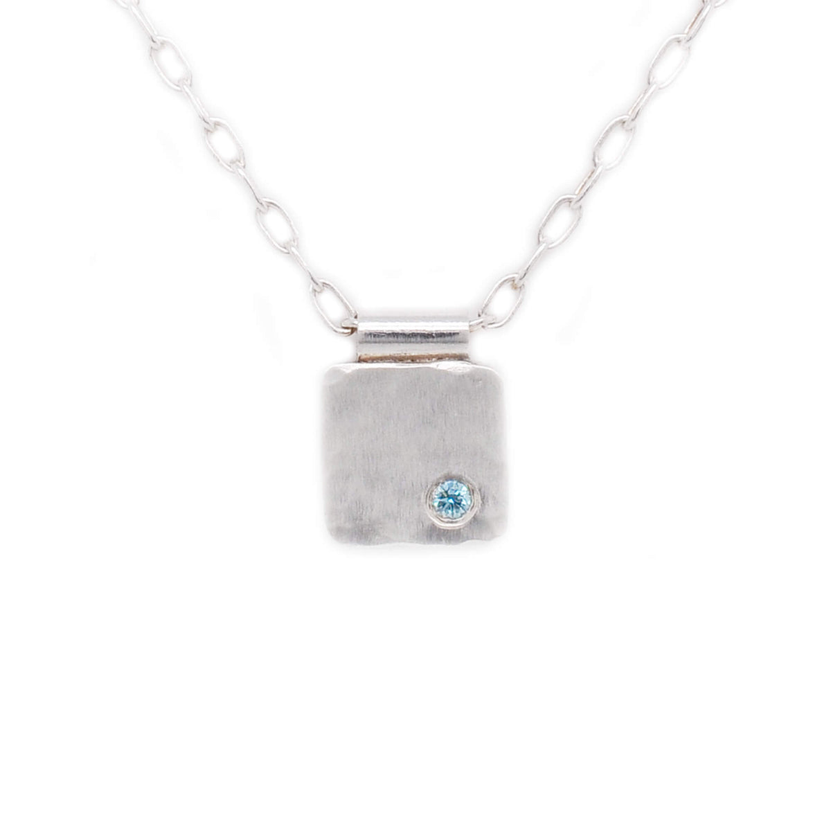 Hammered sterling silver cell necklace with teal blue diamond accent. Handmade by EC Design Jewelry in Minneapolis, MN.