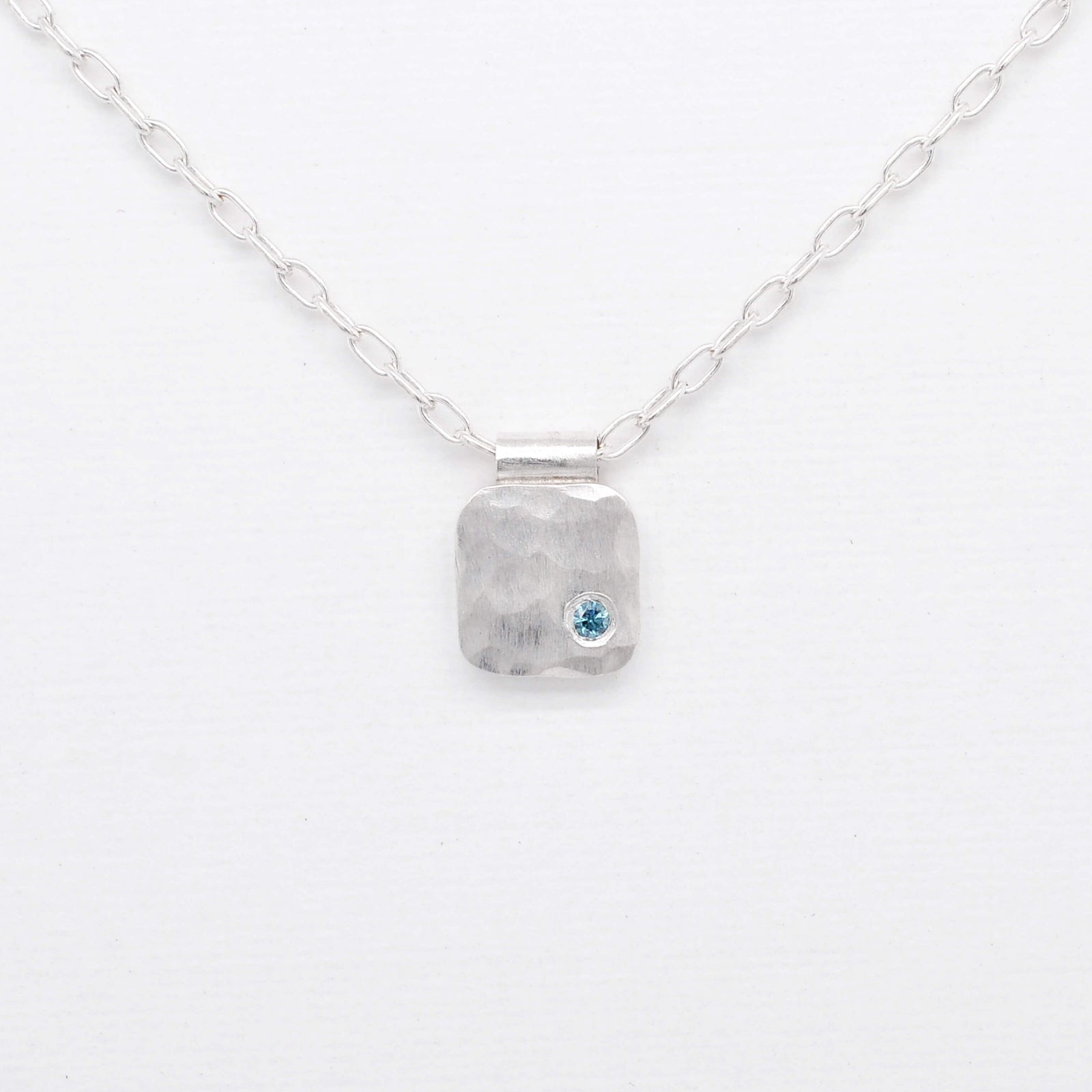 Hammered silver cell pendant with teal blue diamond. Handmade by EC Design Jewelry in Minneapolis, MN.