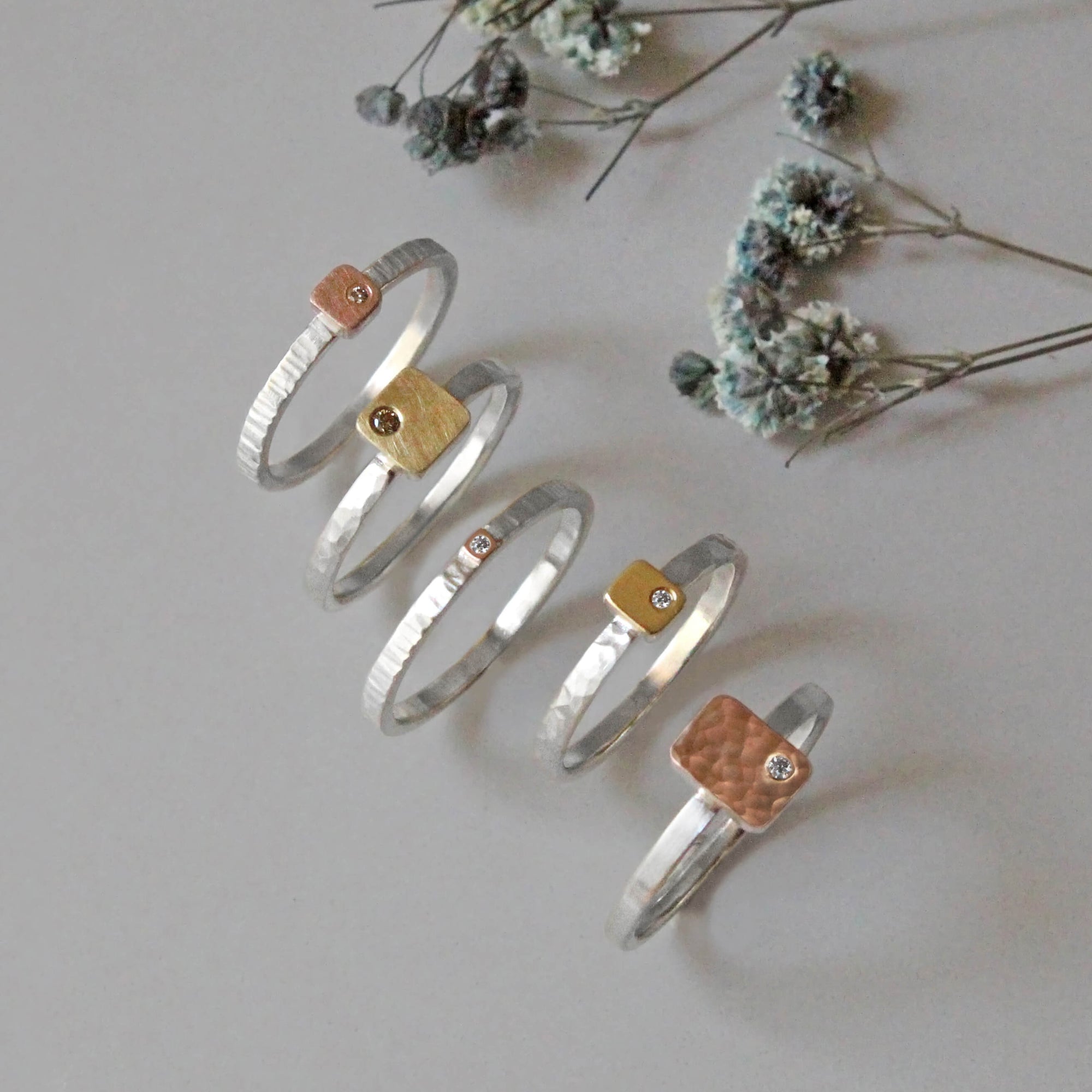 Hammered rose gold cell with white diamond on a sterling silver band. Handmade by EC Design Jewelry in Minneapolis, MN.
