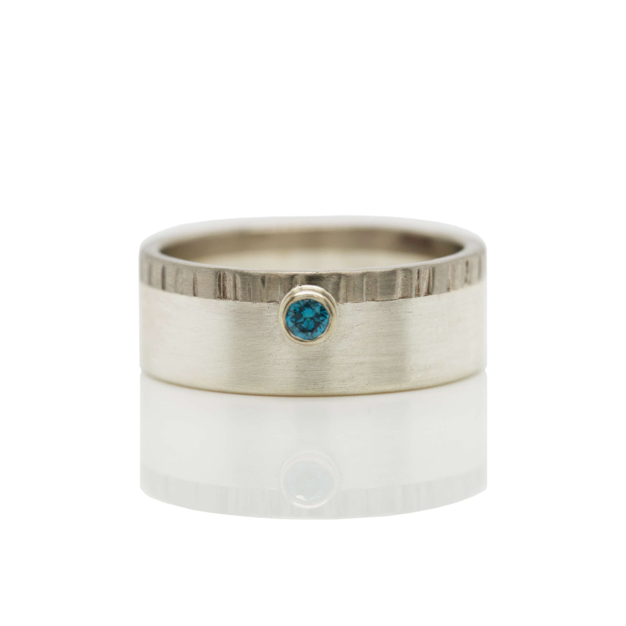 Sterling silver and palladium wedding band with blue diamond accent.