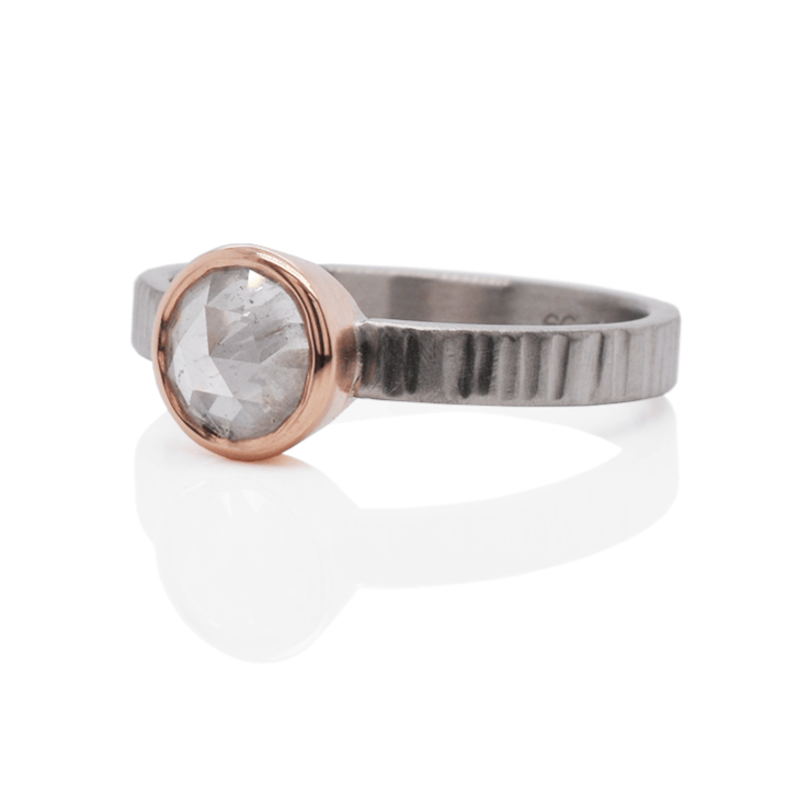 Linear hammered band of palladium with a bezel set white rose cut diamond.