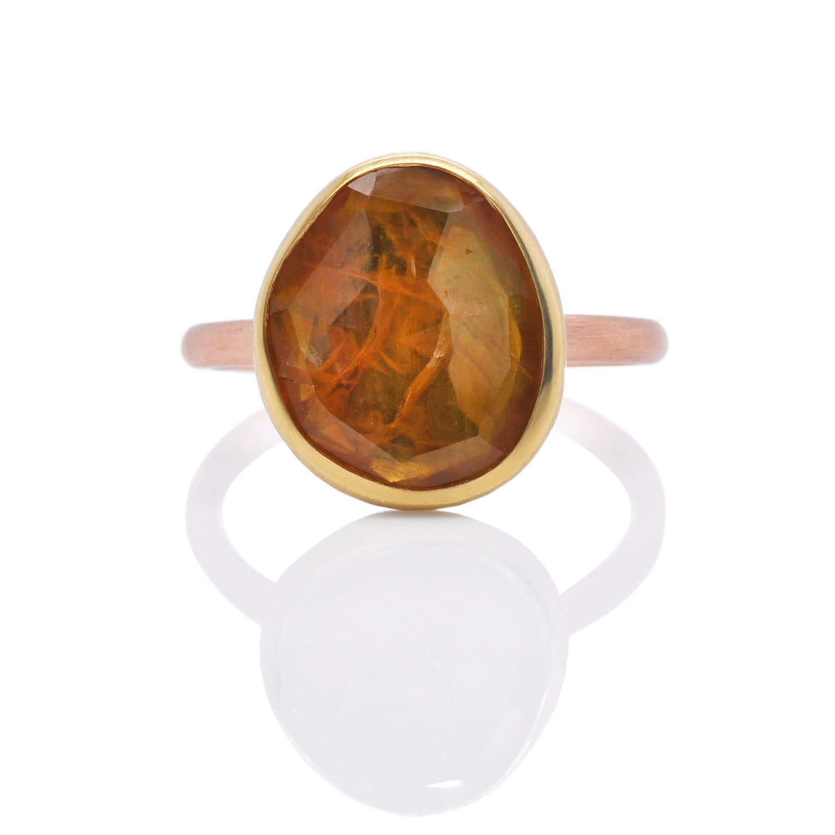 Organic orange sapphire bezel set in yellow gold on a satin finished rose gold band. Handmade by EC Design Jewelry in Minneapolis, MN.