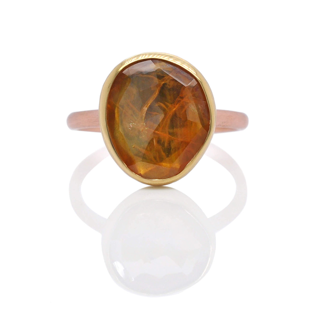 Organic orange sapphire bezel set in yellow gold on a satin finished rose gold band. Handmade by EC Design Jewelry in Minneapolis, MN.