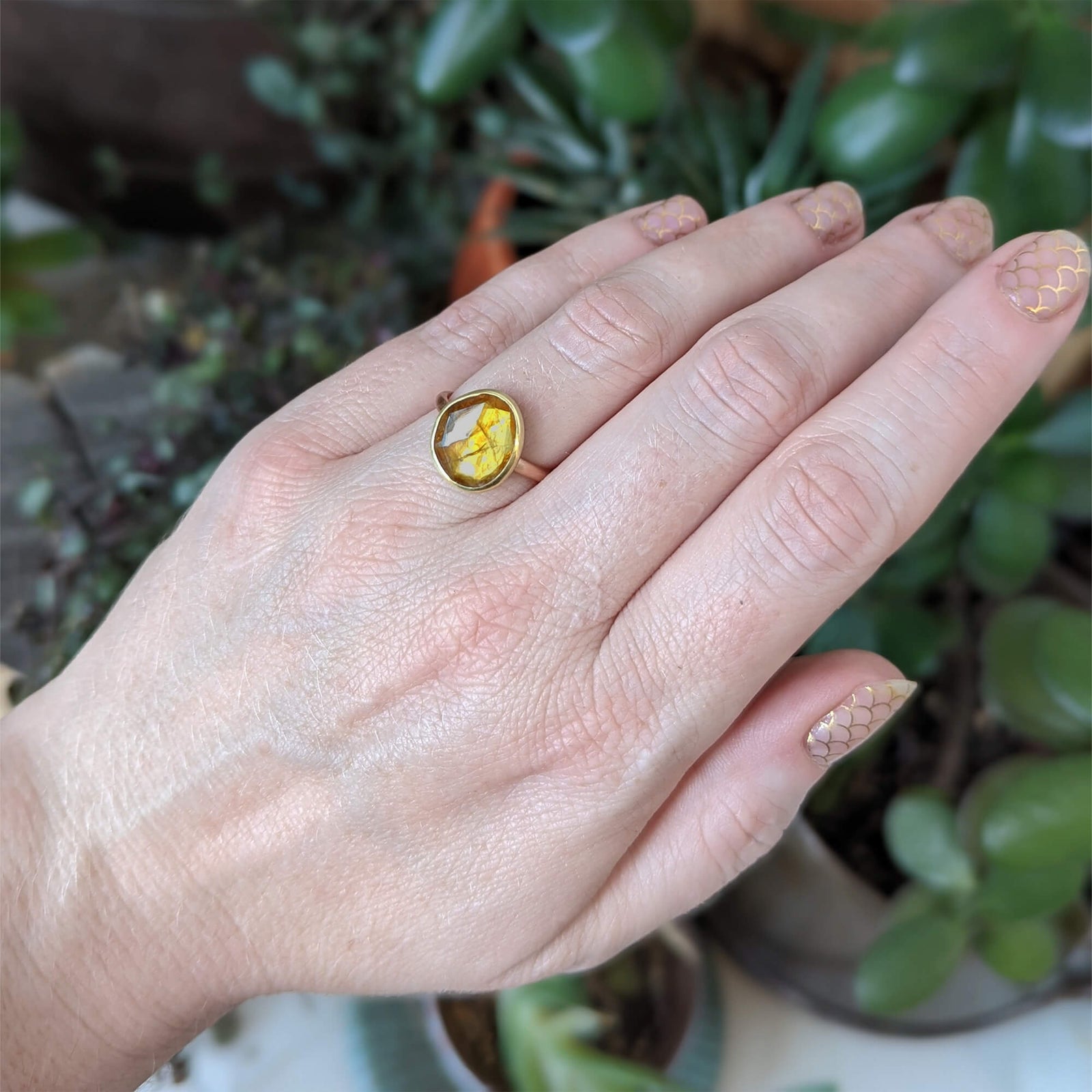 Organic orange sapphire bezel set in yellow gold on a satin finished rose gold band. Handmade by EC Design Jewelry in Minneapolis, MN.