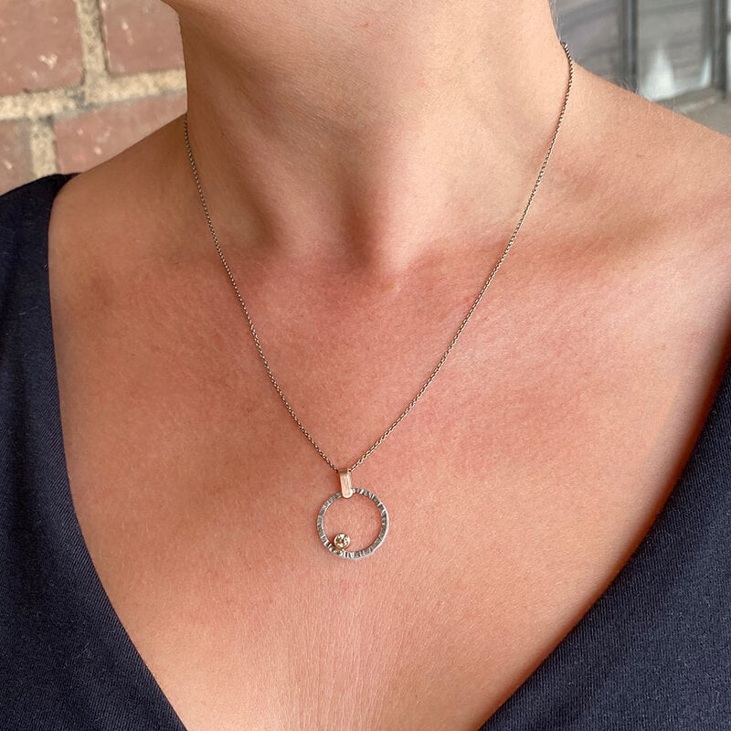 Palladium and rose gold circle pendant with champagne diamond accent. Handmade by EC Design Jewelry in Minneapolis, MN using recycled metal and conflict-free stone.