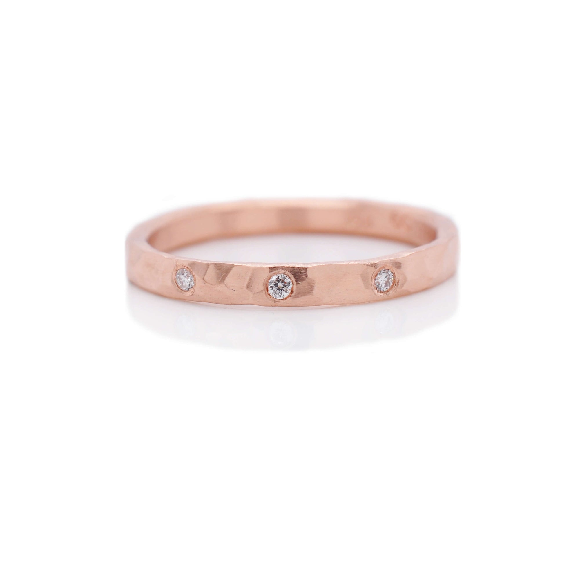 Hammered rose gold half eternity band with 3 flush set white diamonds. Handmade by EC Design Jewelry in Minneapolis, MN.