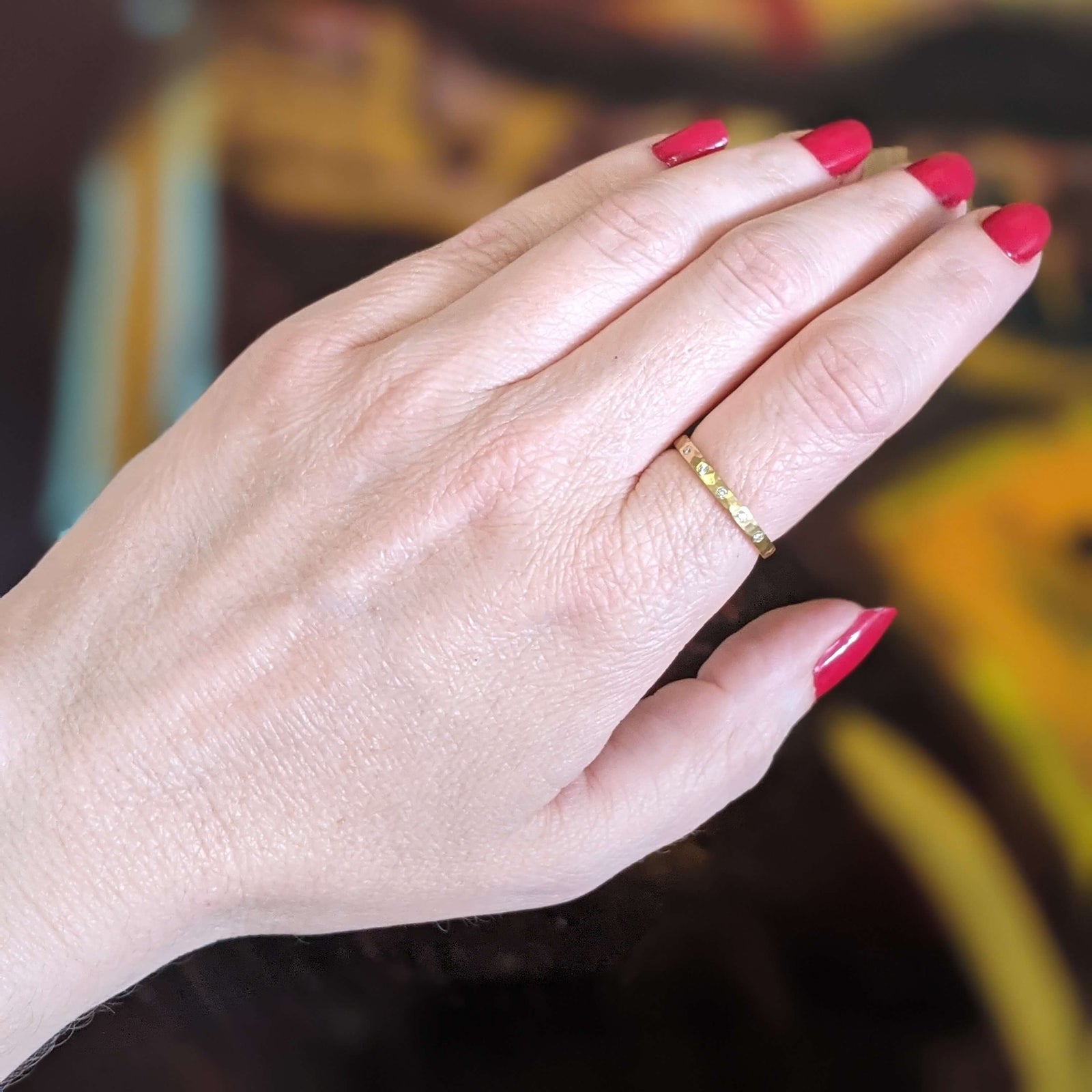 18k yellow gold hammered wedding band with 5 Canadian mined white diamonds. Handmade by EC Design Studio in Minneapolis, MN using recycled metal and conflict-free stones.