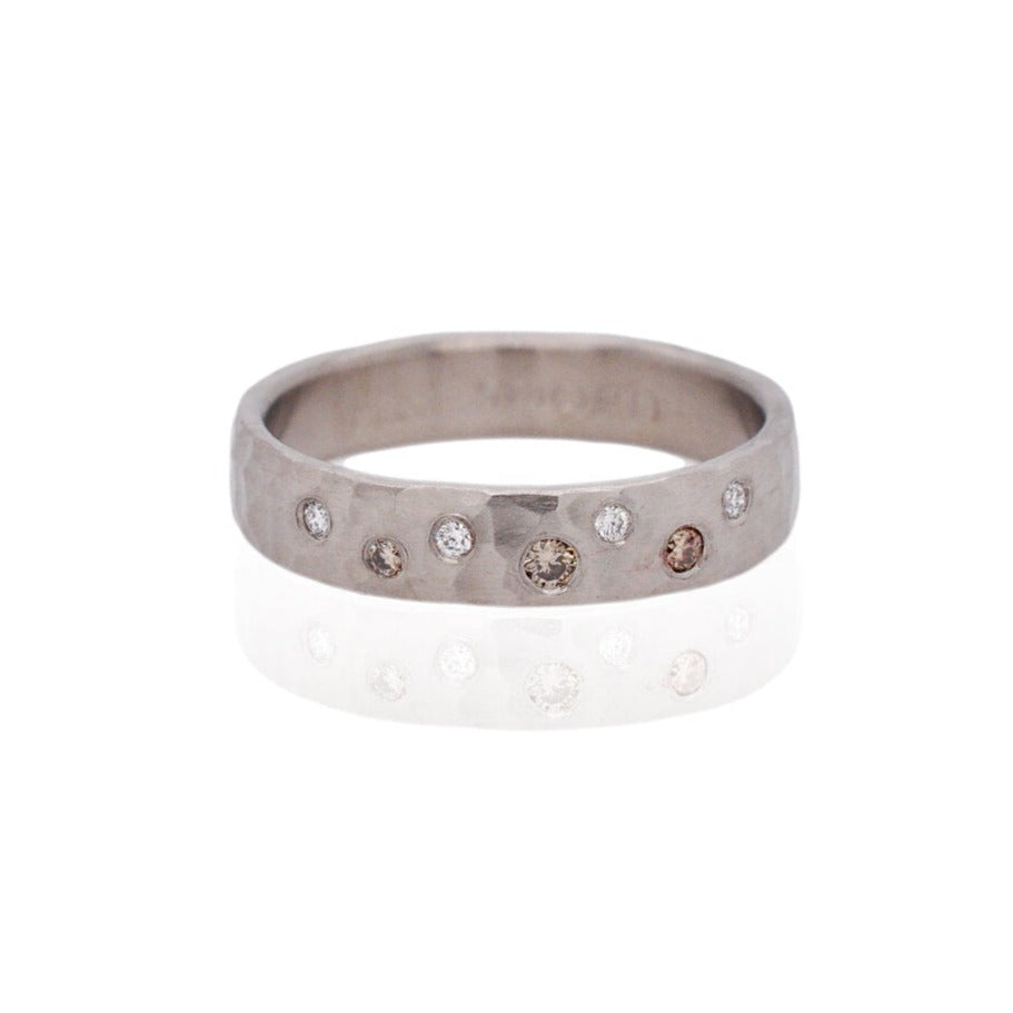 White and champagne diamonds are scattered across a hammered palladium band. Handmade by EC Design Studio in Minneapolis, MN using recycled metal and conflict-free stones.
