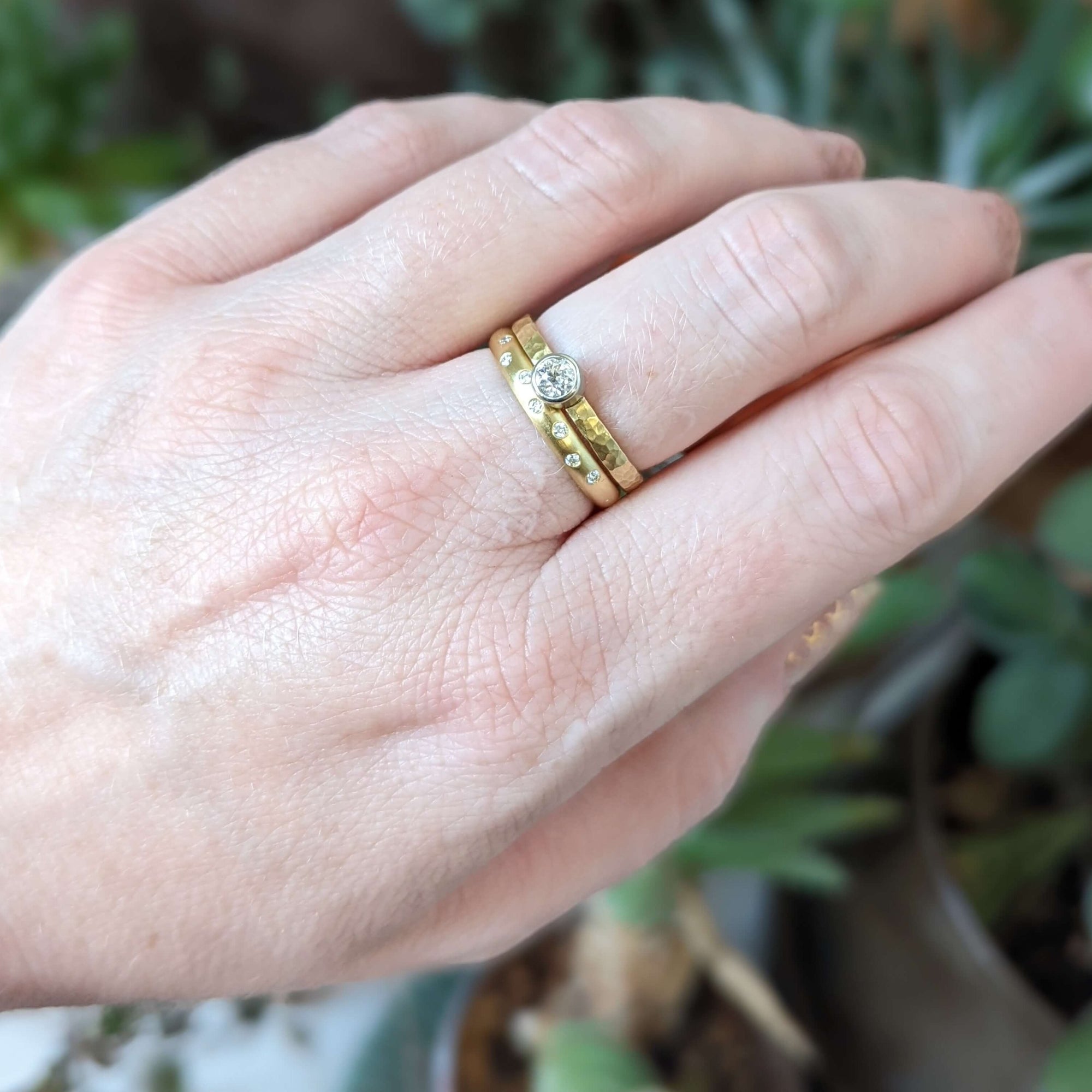 Hand hammered yellow gold band with bezel set round brilliant diamond. Handmade by EC Design Jewelry in Minneapolis, MN.