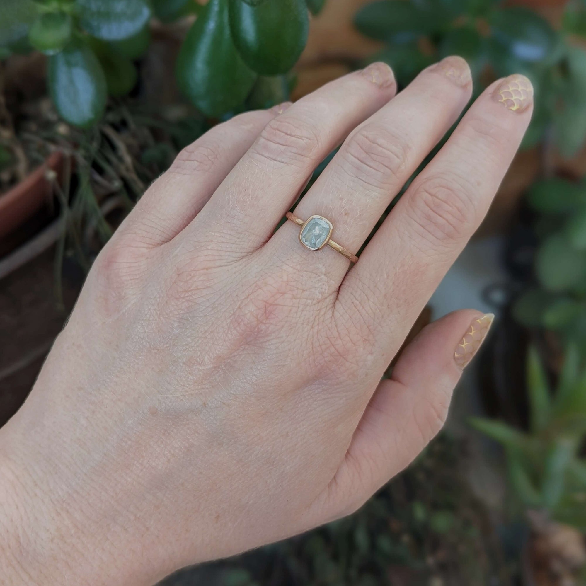 Rectangle diamond bezel set in rose gold on a matching rose gold band with a facet hammered finish.