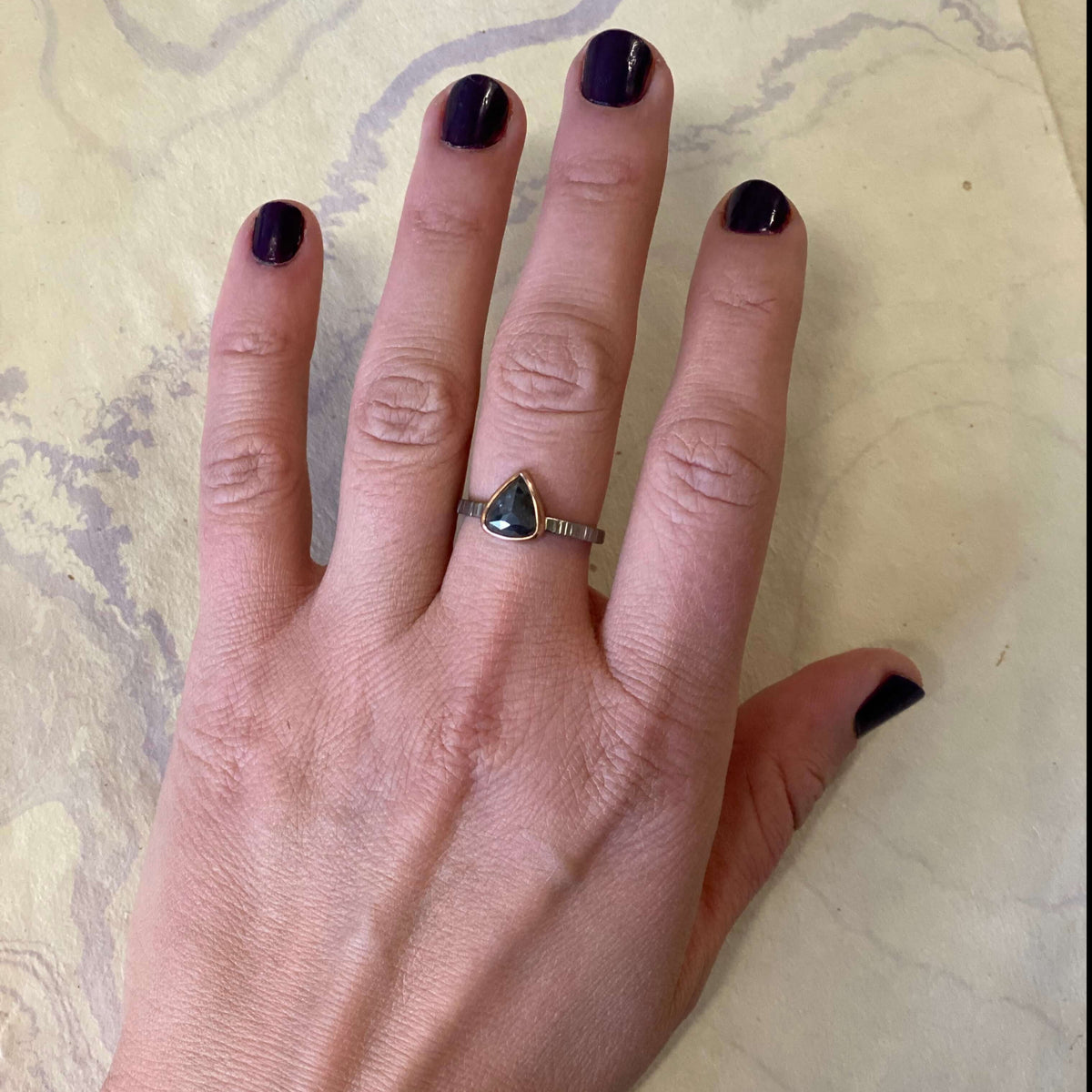 Alternative engagement ring with dark gray diamond bezel set in red gold on a hammered palladium band. Handmade by EC Design Studio in Minneapolis, MN using recycled metal and conflict-free stone.