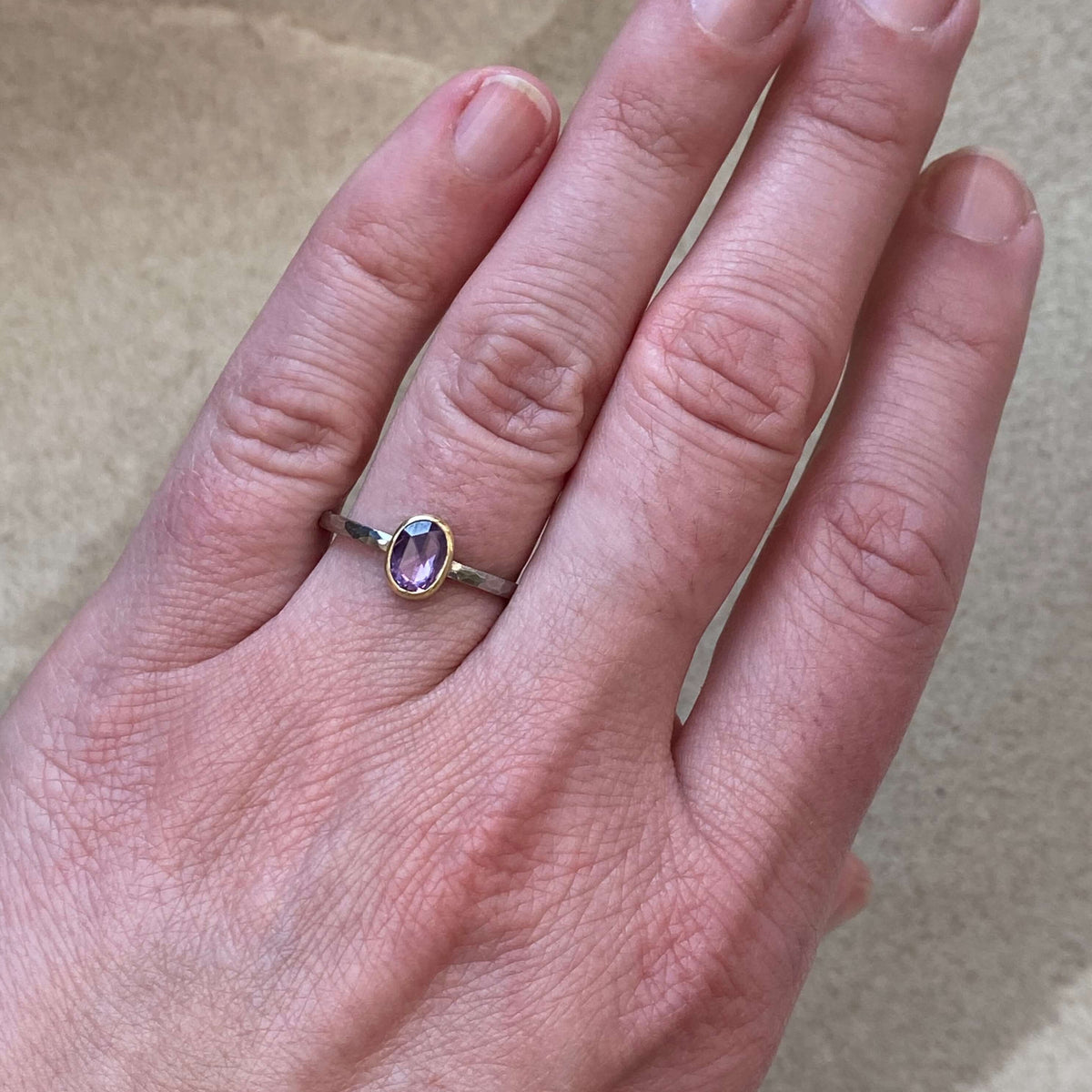 Purple Ceylon sapphire bezel set in yellow gold on a hammered palladium band. Handmade by EC Design Jewelry in Minneapolis, MN using recycled metal and conflict-free stone.