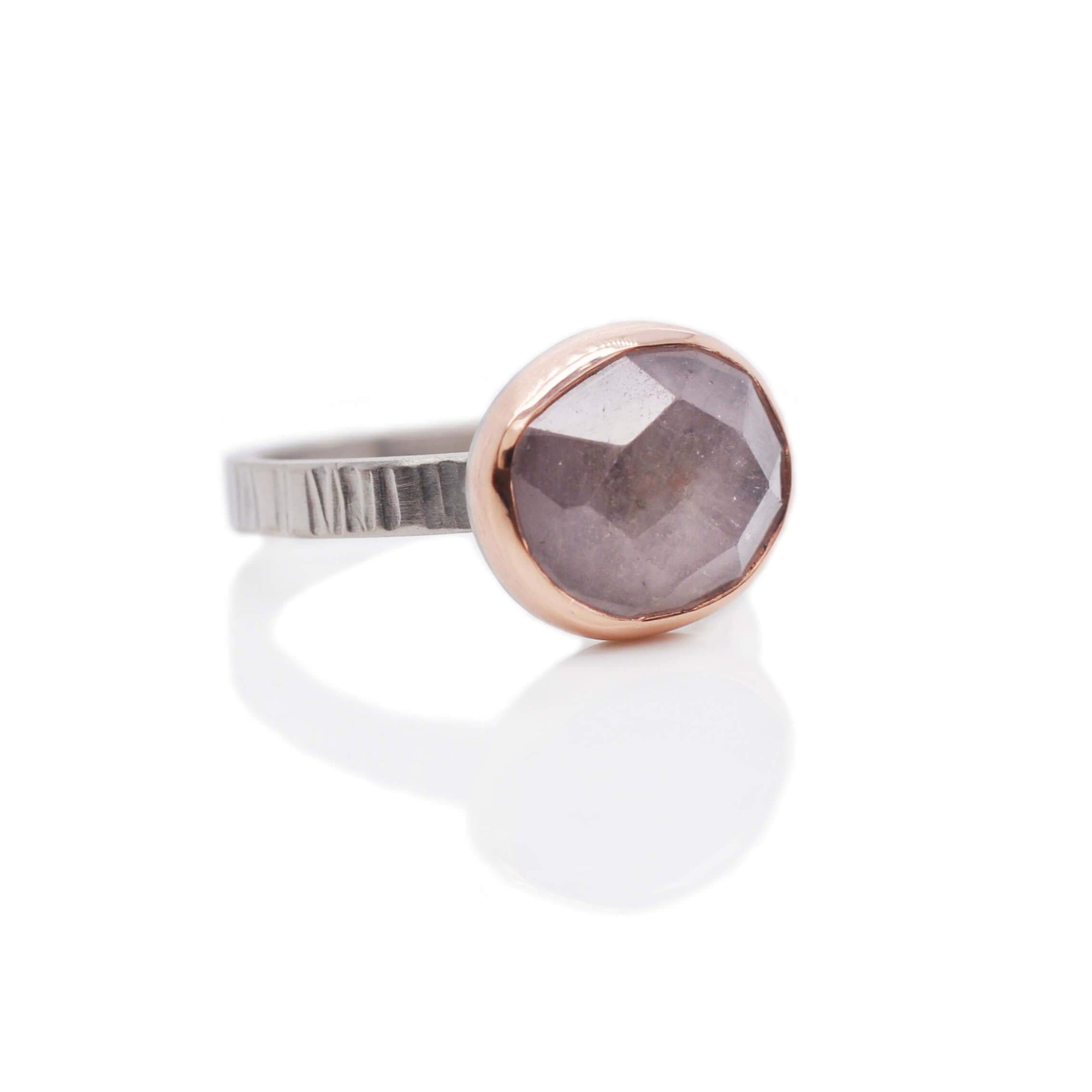 Purple-pink rose cut sapphire in rose gold on a hand hammered band of palladium.