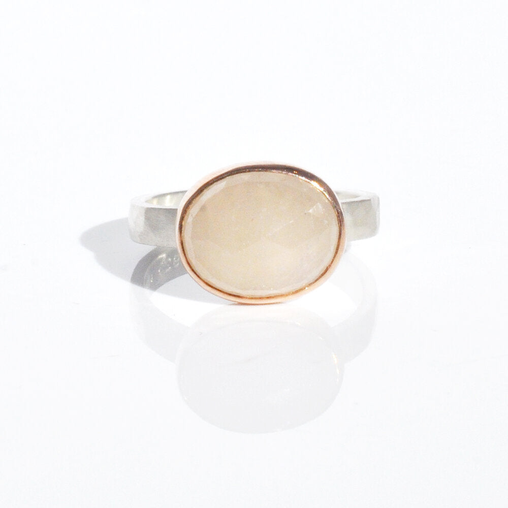 Cream colored rose cut sapphire bezel set in rose gold on a hammered band of sterling silver. Handmade by EC Design Jewelry in Minneapolis, MN.