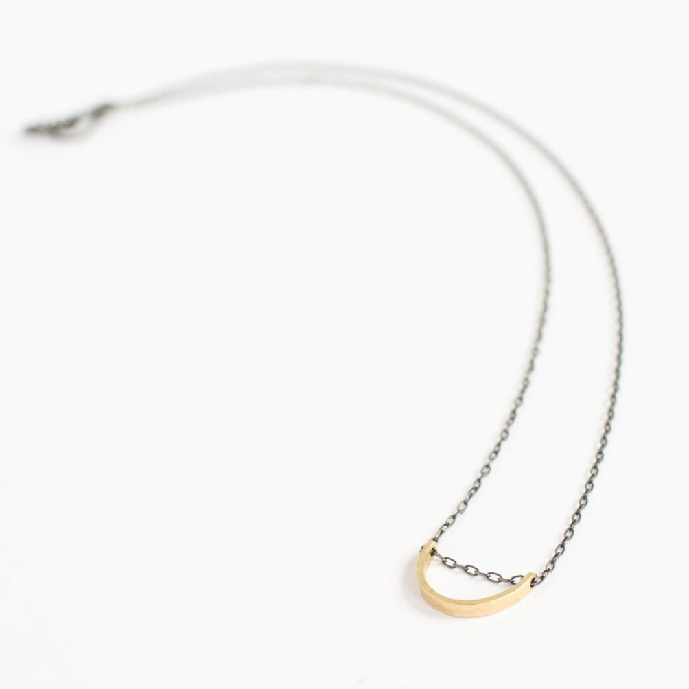 Hammered yellow gold necklace on an oxidized sterling silver chain. Handmade by EC Design Jewelry in Minneapolis, MN using recycled metal.