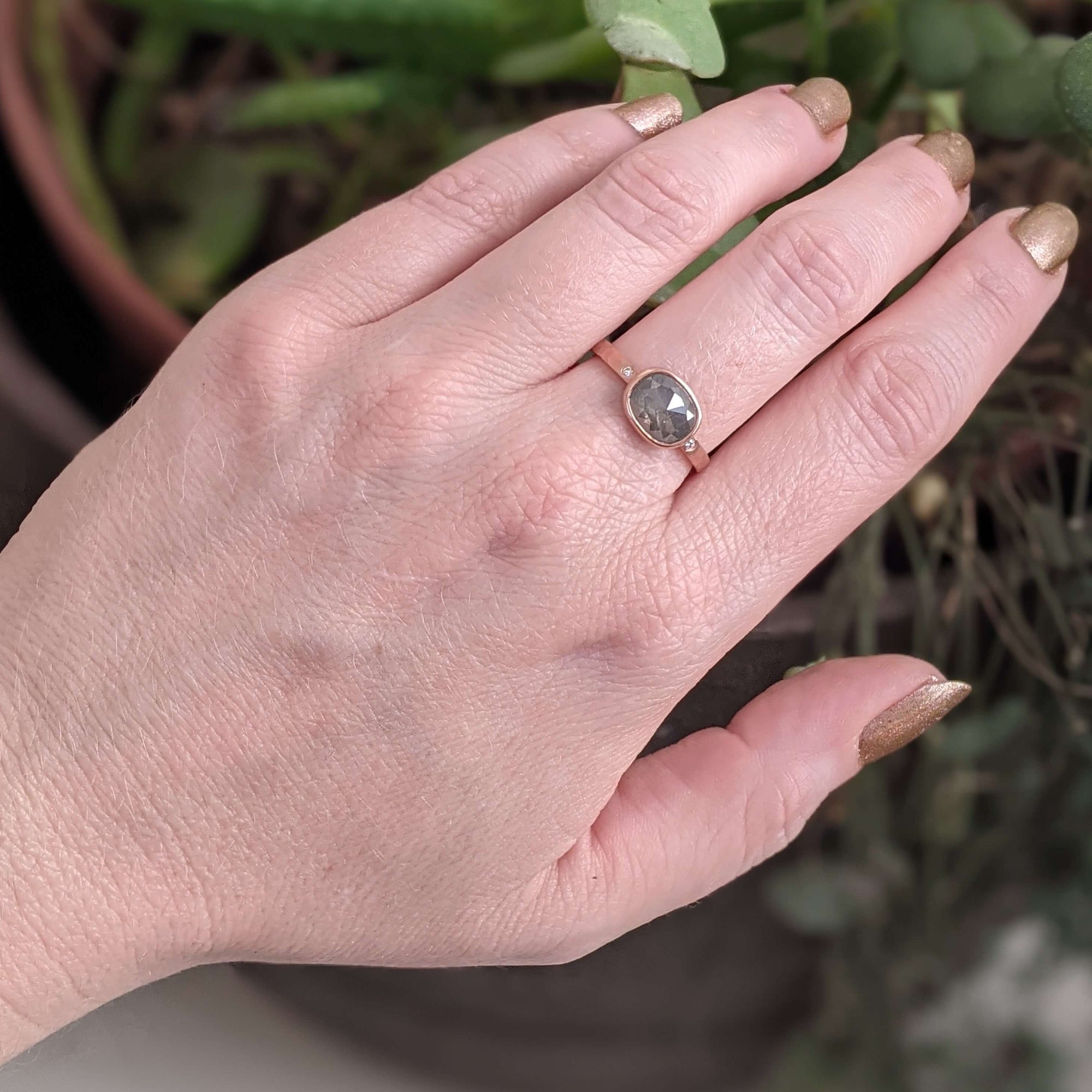 Cushion cut gray diamond in hammered rose gold with flush set diamond accents. Handmade by EC Design Jewelry in Minneapolis, MN using recycled metal and conflict-free stones.